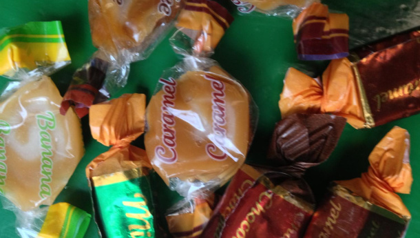 Immagine: Torino, via Bava. Un sacchetto di caramelle  sull'orlo di un cassonetto stradale della plastica.
